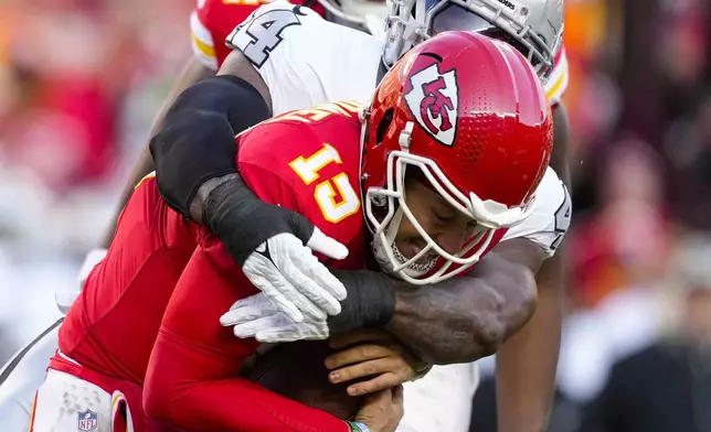 Kansas City Chiefs quarterback Patrick Mahomes (15) is sacked by Las Vegas Raiders defensive end K'Lavon Chaisson (44) during the first half of an NFL football game in Kansas City, Mo., Friday, Nov. 29, 2024. (AP Photo/Ed Zurga)