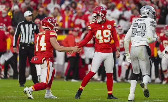 Kansas City Chiefs kicker Matthew Wright (49) celebrates with Matt Araiza (14) after a field goal against the Las Vegas Raiders during the second half of an NFL football game in Kansas City, Mo., Friday, Nov. 29, 2024. (AP Photo/Charlie Riedel)