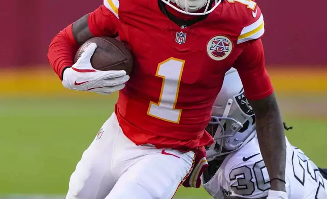 Kansas City Chiefs wide receiver Xavier Worthy (1) is tackled by Las Vegas Raiders cornerback Darnay Holmes (30) during the first half of an NFL football game in Kansas City, Mo., Friday, Nov. 29, 2024. (AP Photo/Charlie Riedel)