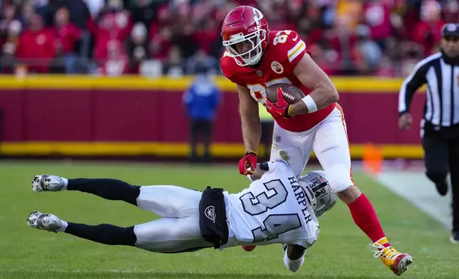 Kansas City Chiefs tight end Travis Kelce (87) is tackled by Las Vegas Raiders safety Thomas Harper (34) during the first half of an NFL football game in Kansas City, Mo., Friday, Nov. 29, 2024. (AP Photo/Ed Zurga)