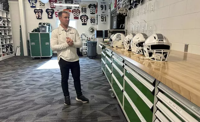 Andrew Kolpacki, Michigan State University's head football equipment manager, surveys players' helmets located on a table inside the school's football complex, Monday, Nov. 18, 2024, in East Lansing, Mich. (AP Photo/Mike Householder)