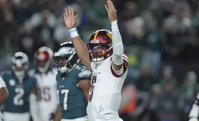 Washington Commanders quarterback Jayden Daniels celebrates a 1-yard touchdown run by Commanders running back Brian Robinson Jr. during the first half of an NFL football game against the Philadelphia Eagles Thursday, Nov. 14, 2024, in Philadelphia. (AP Photo/Chris Szagola)