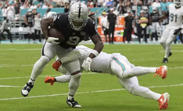 Las Vegas Raiders running back Ameer Abdullah (8) breaks up a tackle by Miami Dolphins cornerback Kader Kohou (4) and runs for a touchdown during the second half of an NFL football game, Sunday, Nov. 17, 2024, in Miami Gardens, Fla. (AP Photo/Rebecca Blackwell)