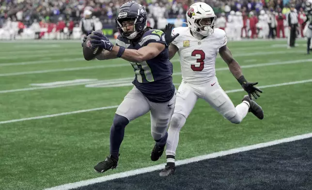 Seattle Seahawks wide receiver Jaxon Smith-Njigba (11) scores a touchdown as Arizona Cardinals safety Budda Baker (3) defends during the first half of an NFL football game Sunday, Nov. 24, 2024, in Seattle. (AP Photo/Stephen Brashear)