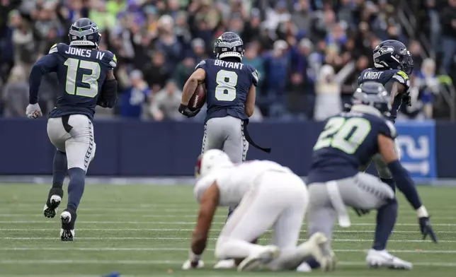 Seattle Seahawks cornerback Coby Bryant (8) runs the ball for a touchdown after making an interception during the second half of an NFL football game against the Arizona Cardinals, Sunday, Nov. 24, 2024, in Seattle. (AP Photo/Jason Redmond)