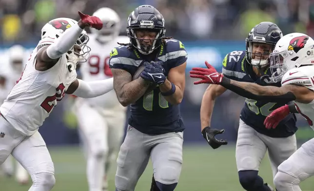 Seattle Seahawks wide receiver Jaxon Smith-Njigba (11) runs the ball for 46 yards, setting up a touchdown during the first half of an NFL football game against the Arizona Cardinals, Sunday, Nov. 24, 2024, in Seattle. (AP Photo/Jason Redmond)