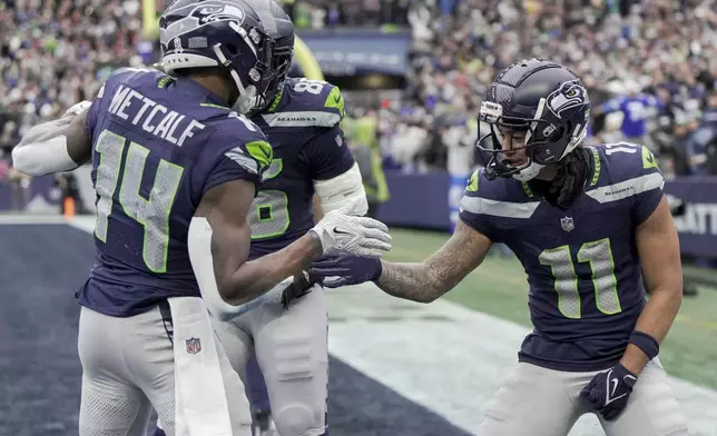 Seattle Seahawks wide receiver Jaxon Smith-Njigba (11) celebrates with wide receiver DK Metcalf (14) after he scored a touchdown during the first half of an NFL football game against the Arizona Cardinals, Sunday, Nov. 24, 2024, in Seattle. (AP Photo/Stephen Brashear)