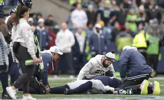 Seattle Seahawks cornerback Riq Woolen (27) lies on the field after being injured during the second half of an NFL football game against the Arizona Cardinals, Sunday, Nov. 24, 2024, in Seattle. (AP Photo/Jason Redmond)