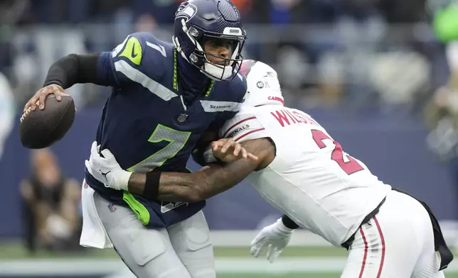 Seattle Seahawks quarterback Geno Smith (7) is pressured by Arizona Cardinals linebacker Mack Wilson Sr. (2) during the first half of an NFL football game Sunday, Nov. 24, 2024, in Seattle. (AP Photo/Stephen Brashear)