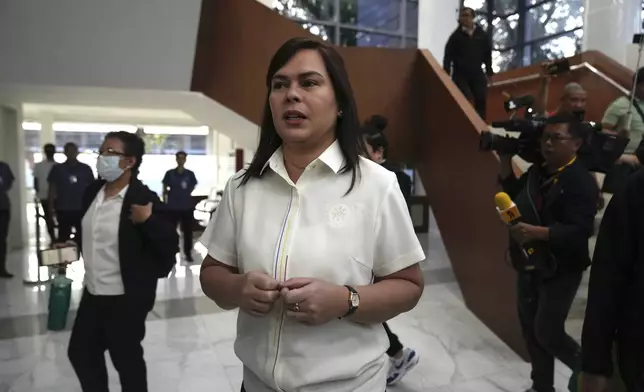 Philippine Vice President Sara Duterte, center, walks while a hearing she is attending is suspended at the House of Representative in Quezon City, Philippines Monday, Nov. 25, 2024. (AP Photo/Aaron Favila)