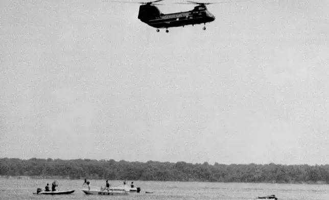 FiLE - Military rescue workers and boaters arrive on the scene of a crash, shortly after it happened, of an experimental V-22 Osprey tilt-rotor aircraft in the Potomac River just off the Quantico Marine Air Station, July 20, 1992, in Quantico, Va. (AP Photo/Bill Kramer)