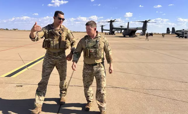 Osprey pilot Maj. Lucas Duncavage and squadron commander Lt. Col. Seth Buckley talk over their V-22 Osprey training flight just after landing, at Cannon Air Force Base, N.M., Oct. 9, 2024. During the flight they sped 100 feet off the ground on a training range named the Hornet. (AP Photo/Tara Copp)