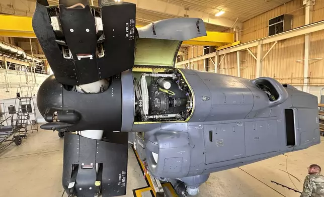 A service member walks under the Osprey nacelle, which houses both the Osprey's engine and transmission system and bends upward like an elbow during vertical flight at Cannon Air Force Base, N.M., Oct. 8, 2024. The open panel shows the proprotor gearbox, which serves as the transmission and has been a factor in multiple crashes after parts wore down and broke apart in flight. (AP Photo/Tara Copp)