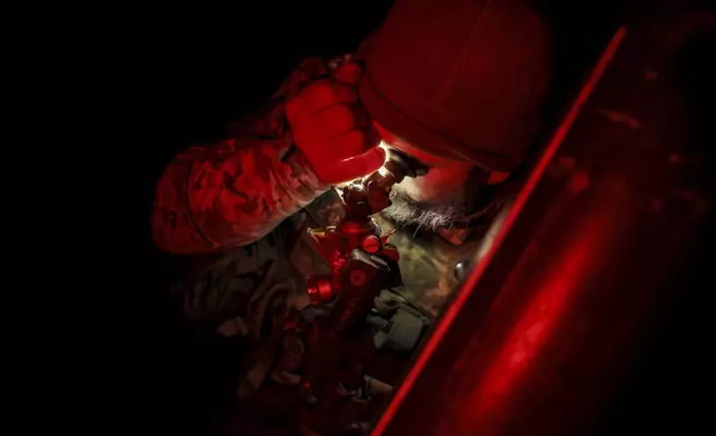 In this photo provided by Ukraine's 24th Mechanised Brigade press service, serviceman of the 24th Mechanised Brigade prepares to fire 120mm mortar towards Russian positions near Chasiv Yar town, in Donetsk region, Ukraine, Tuesday, Nov. 19, 2024. (Oleg Petrasiuk/Ukrainian 24th Mechanised Brigade via AP)