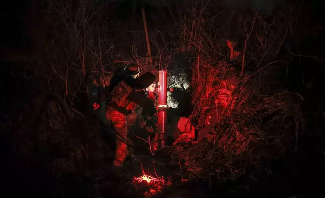 In this photo provided by Ukraine's 24th Mechanised Brigade press service, serviceman of the 24th Mechanised Brigade prepares to fire 120mm mortar towards Russian positions near Chasiv Yar town, in Donetsk region, Ukraine, Tuesday, Nov. 19, 2024. (Oleg Petrasiuk/Ukrainian 24th Mechanised Brigade via AP)