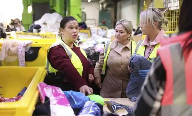 Sinn Fein leader Mary Lou McDonald, left, meets workers during a visit to Liberty Recycling in Dublin, Ireland, Tuesday, Nov. 26, 2024, ahead of Ireland's election on Friday. (AP Photo/Peter Morrison)