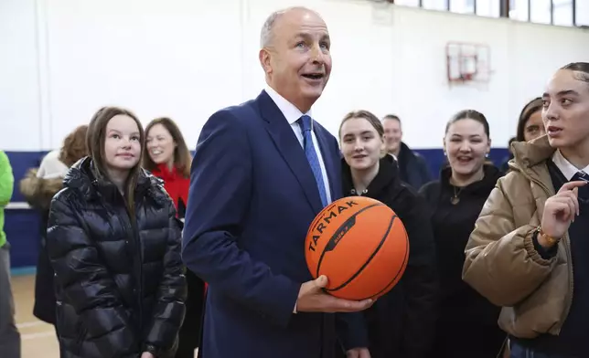 Micheal Martin, center, Tanaiste of Ireland and leader of Fianna Fail meets pupils at St Seton's Secondary School in Ballyfermot, Dublin, Ireland, Tuesday, Nov. 26, 2024. (AP Photo/Peter Morrison)