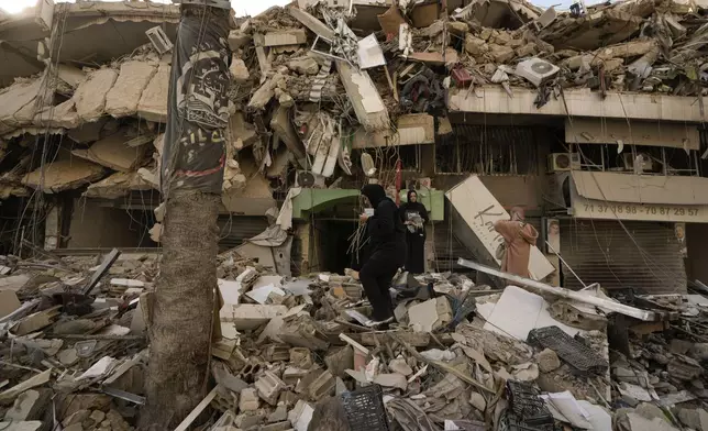 Women try to salvage items from the rubble of a destroyed building in Dahiyeh, Beirut, Lebanon, Friday, Nov. 29, 2024. (AP Photo/Bilal Hussein)