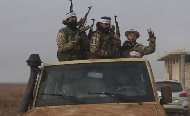 Syrian opposition fighters ride in a truck in Talhiya, Idlib countryside, Syria, Friday, Nov. 29, 2024. (AP Photo/Ghaith Alsayed)