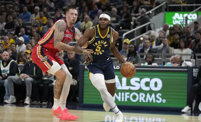 Indiana Pacers' Jarace Walker (5) is defended by New Orleans Pelicans' Daniel Theis (10) during the first half of an NBA basketball game, Monday, Nov. 25, 2024, in Indianapolis. (AP Photo/Darron Cummings)