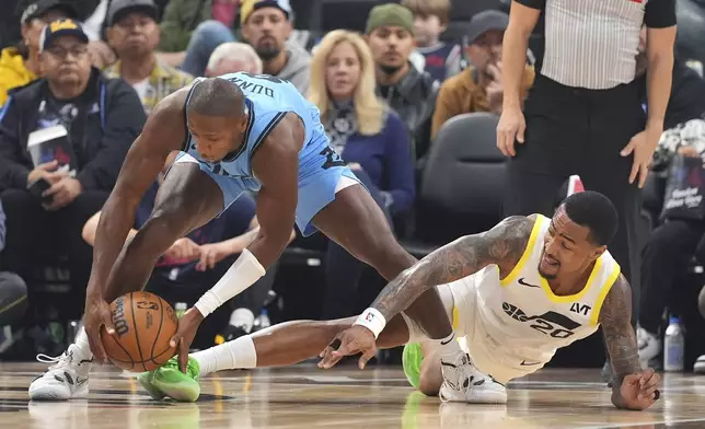 Los Angeles Clippers guard Kris Dunn, left, grabs a loose ball away from Utah Jazz forward John Collins during the first half of an NBA basketball game, Sunday, Nov. 17, 2024, in Inglewood, Calif. (AP Photo/Mark J. Terrill)