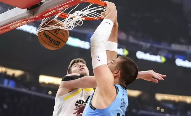 Los Angeles Clippers center Ivica Zubac, right, dunks as Utah Jazz forward Kyle Filipowski defends during the first half of an NBA basketball game, Sunday, Nov. 17, 2024, in Inglewood, Calif. (AP Photo/Mark J. Terrill)