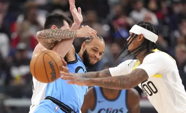 Utah Jazz guard Jordan Clarkson, right, passes the ball as forward Drew Eubanks, left, and Los Angeles Clippers guard Amir Coffey tie each other up during the first half of an NBA basketball game, Sunday, Nov. 17, 2024, in Inglewood, Calif. (AP Photo/Mark J. Terrill)