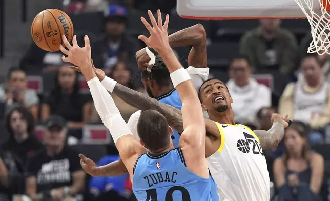 Utah Jazz forward John Collins, right, and Los Angeles Clippers center Ivica Zubac reach for a rebound during the first half of an NBA basketball game, Sunday, Nov. 17, 2024, in Inglewood, Calif. (AP Photo/Mark J. Terrill)