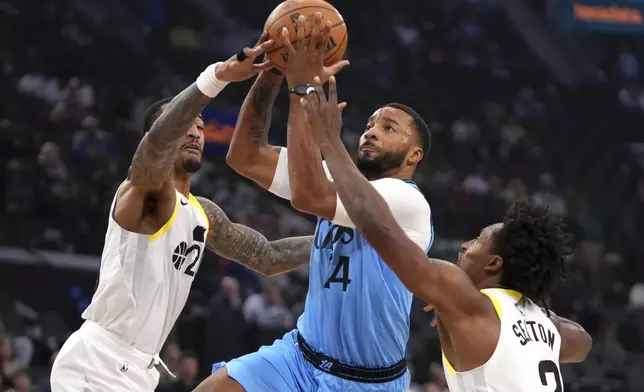 Los Angeles Clippers guard Norman Powell, center, shoots as Utah Jazz forward John Collins, left, and guard Collin Sexton defend during the first half of an NBA basketball game, Sunday, Nov. 17, 2024, in Inglewood, Calif. (AP Photo/Mark J. Terrill)