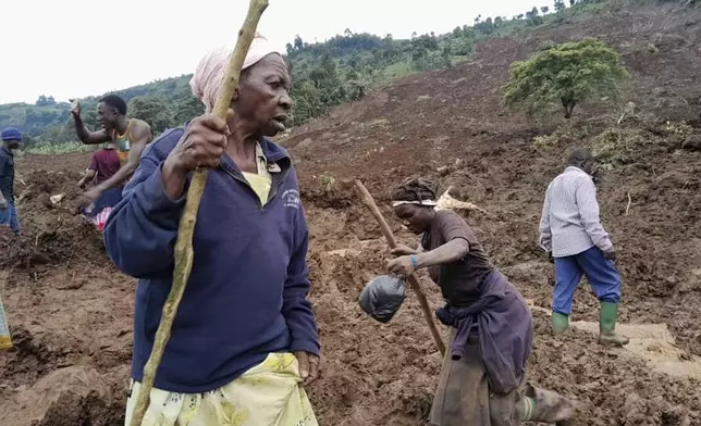 People search for bodies after landslides following heavy rains buried 40 homes in the mountainous district of Bulambuli, eastern Uganda, Thursday, Nov. 28. 2024. (AP Photo/Jean Watala)