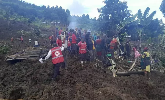 Uganda Red Cross workers search for bodies after a landslide following heavy rains buried 40 homes in the mountainous district of Bulambuli, eastern Uganda, Thursday, Nov. 28. 2024. (AP Photo/Irene Nakasiita)