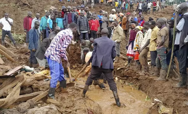 Rescue workers and people search for bodies after landslides following heavy rains buried 40 homes in the mountainous district of Bulambuli, eastern Uganda, Thursday, Nov. 28. 2024. (AP Photo/Jean Watala)