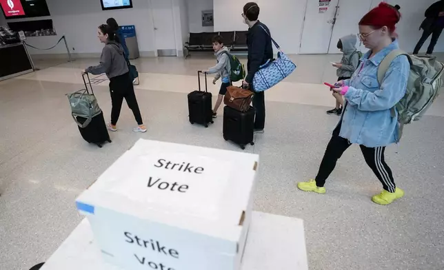 Passengers walks past a union ballot drop box at Charlotte Douglas International Airport, Friday, Nov. 22, 2024, in Charlotte, N.C. (AP Photo/Erik Verduzco)