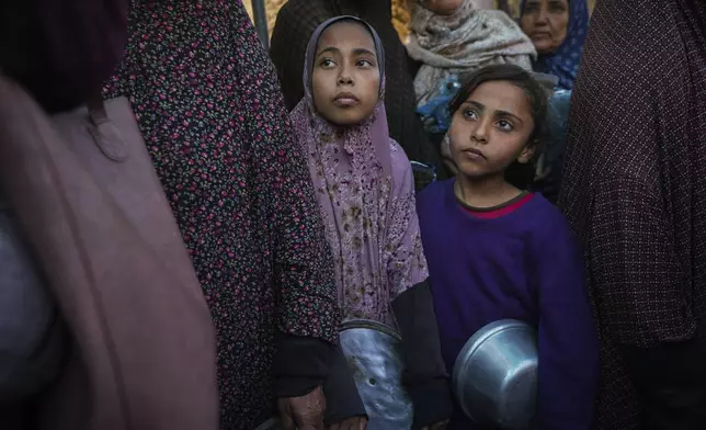 Palestinian children queue at a food distribution kitchen in Deir al-Balah, Gaza Strip, Friday Nov. 22, 2024. (AP Photo/Abdel Kareem Hana)