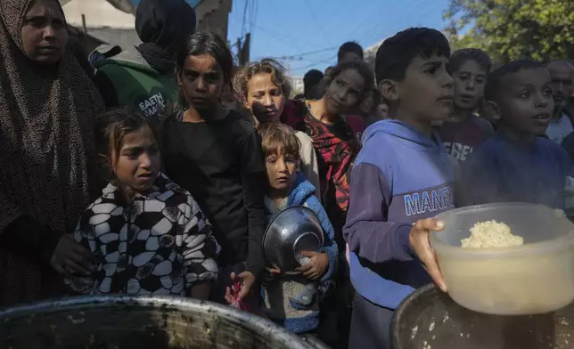 Palestinian children queue at a food distribution kitchen in Deir al-Balah, Gaza Strip, Friday Nov. 22, 2024. (AP Photo/Abdel Kareem Hana)