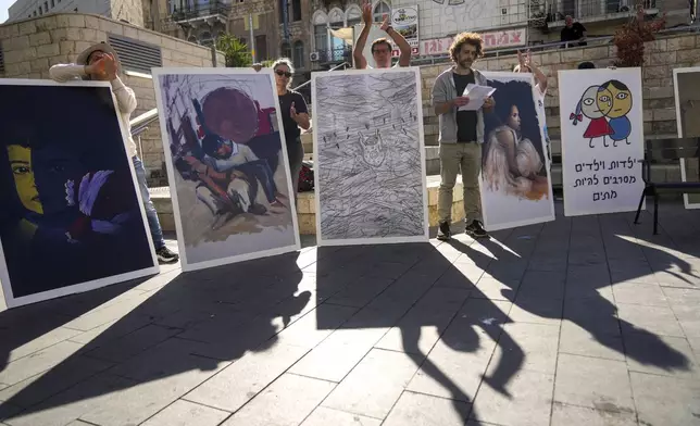 People hold boards during a protest against Israel's military operations in the Gaza Strip and Lebanon and calling for the release of hostages held in the Gaza Strip by the Hamas militant group, in Haifa, Israel, Friday, Nov. 22, 2024. Placard on the right reads “Children refuse to die”. (AP Photo/Francisco Seco)