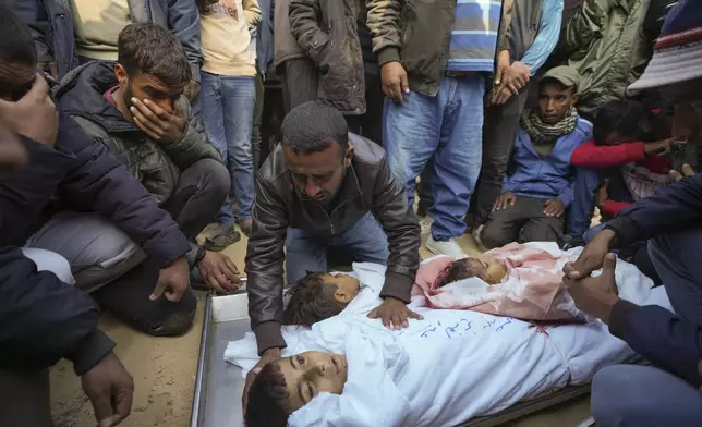 Mahmoud bin Hassan mourns over the bodies his three children before their funeral in Khan Younis, Gaza Strip, Thursday Nov. 21, 2024. Seven-year-old Hamza, his five-year-old brother Abdelaziz, and his four-year-old sister Laila Hassan were among 9 people killed by an Israeli strike in Khan Younis on Wednesday. Palestinian health officials say the death toll in the Gaza Strip from the 13-month-old war between Israel and Hamas has surpassed 44,000. (AP Photo/Abdel Kareem Hana)