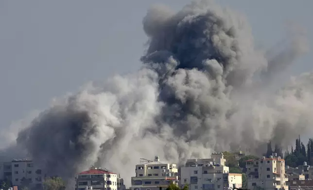 Smoke rises between buildings hit in an Israeli airstrike in Burj al-Shamali village, as seen from Tyre city, south Lebanon, Friday, Nov. 22, 2024. (AP Photo/Hussein Malla)