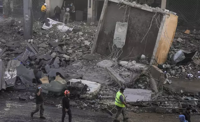 Rescuers check a building hit by an Israeli airstrike in Chiyah, the southern suburb of Beirut, Lebanon, Friday, Nov. 22, 2024. (AP Photo/Bilal Hussein)