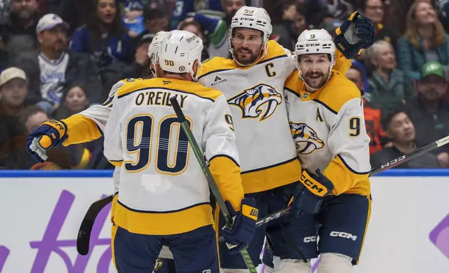 Nashville Predators' Ryan O'Reilly (90), Roman Josi (59), and Filip Forsberg (9) celebrate a goal during second period an NHL hockey match in Vancouver, on Sunday, Nov. 17, 2024. (Christopher Morris/The Canadian Press via AP)