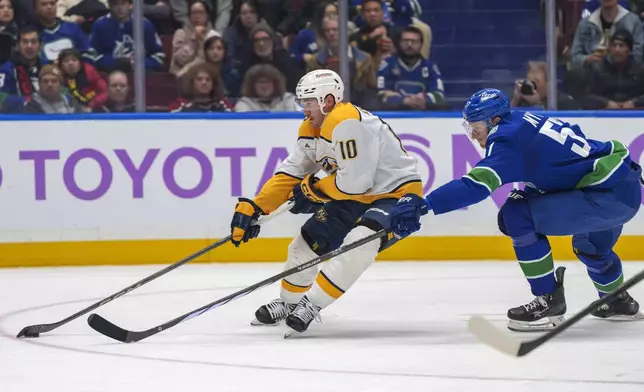 Nashville Predators' Colton Sissons (10) gets past Vancouver Canucks' Tyler Myers (57) during second period an NHL hockey match in Vancouver, on Sunday, Nov. 17, 2024. (Christopher Morris/The Canadian Press via AP)