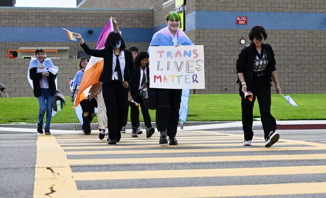 FILE - Students carrying pride and transgender flags leave Great Oak High School in Temecula, Calif., Friday, Sept. 22, 2023, after walking out of the school in protest of the Temecula school district policy requiring parents to be notified if their child identifies as transgender. (Anjali Sharif-Paul/The Orange County Register via AP, File)