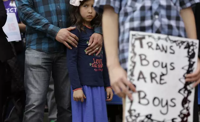 FILE - Libby Gonzales stands with her father, Frank Gonzales, as she joins other members of the transgender community during a rally on the steps of the Texas Capitol, Monday, March 6, 2017, in Austin, Texas. The group is opposing a "bathroom bill" that would require people to use public bathrooms and restrooms that correspond with the sex on their birth certificate. (AP Photo/Eric Gay, File)