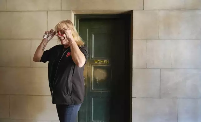 FILE - Jessie McGrath walks out of the women's bathroom at the Nebraska State Capitol in Lincoln, Neb., on Wednesday, Oct. 2, 2024. McGrath said when she was testifying against LB575, "I actually used it (the women's restroom) with a number of you senators today, and I don't think that the world has come to an end, has it?" (AP Photo/Brynn Anderson, File)