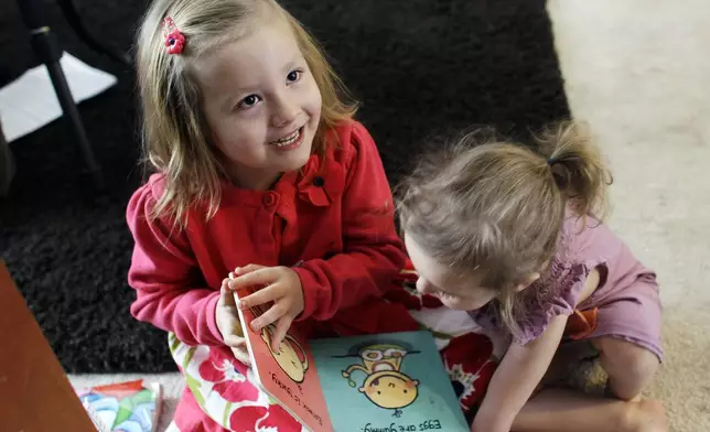 FILE - Coy Mathis, left, plays with her sister Auri, at their home in Fountain, Colo., on Monday, Feb. 25, 2013. Coy has been diagnosed with Gender Identity Disorder. Biologically, Coy, 6, is a boy, but to her family members and the world, Coy is a transgender girl. (AP Photo/Brennan Linsley, File)