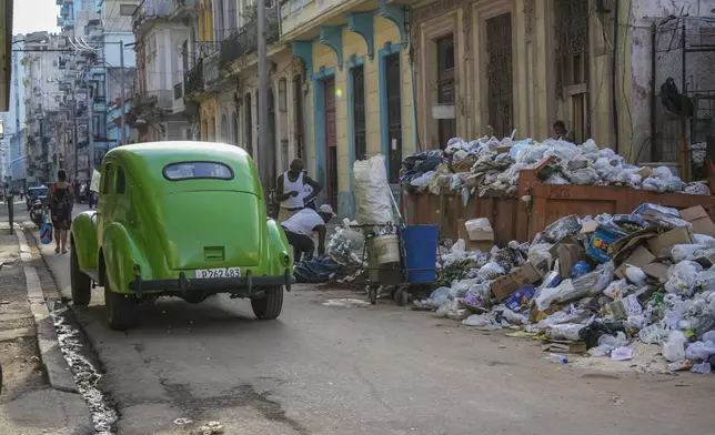 FILE - A classic American car drives past garbage in Havana, Cuba, Sept. 24, 2024. (AP Photo/Ramon Espinosa, File)