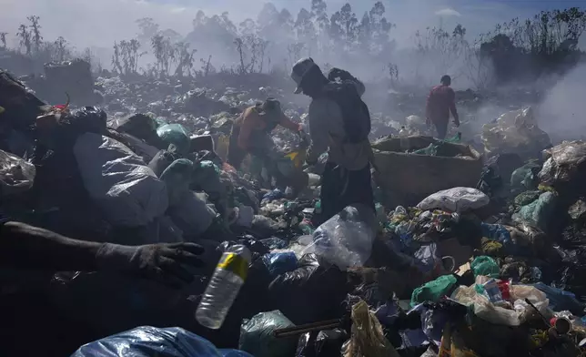 FILE - Recyclable collectors work at the Lixao open-air dump in Santo Antonio do Descoberto, Goias state, Brazil, June 4, 2024. (AP Photo/Eraldo Peres, File)