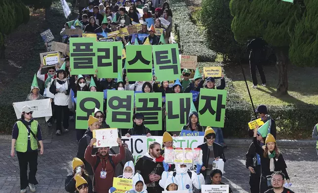 Environment activists march during a rally calling for a strong global plastics treaty ahead of the fifth session of the Intergovernmental Negotiating Committee on Plastic Pollution which sets to be held from Nov. 25 to Dec. 1 in Busan, South Korea, Saturday, Nov. 23, 2024. A signs at center reads "Let's end plastic pollution." (Son Hyung-joo/Yonhap via AP)