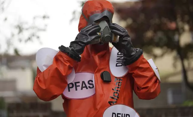 An environment activist wearing a suit prepares for a rally calling for a strong global plastics treaty ahead of the fifth session of the Intergovernmental Negotiating Committee on Plastic Pollution which set to be held in Busan from Nov. 25 to Dec. 1, in Seoul, South Korea, Wednesday, Nov. 20, 2024. (AP Photo/Lee Jin-man)