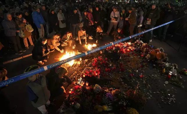 People light candles for the victims after an outdoor roof collapsed at a train station in Novi Sad, Serbia, Saturday, Nov. 2, 2024. (AP Photo/Darko Vojinovic)